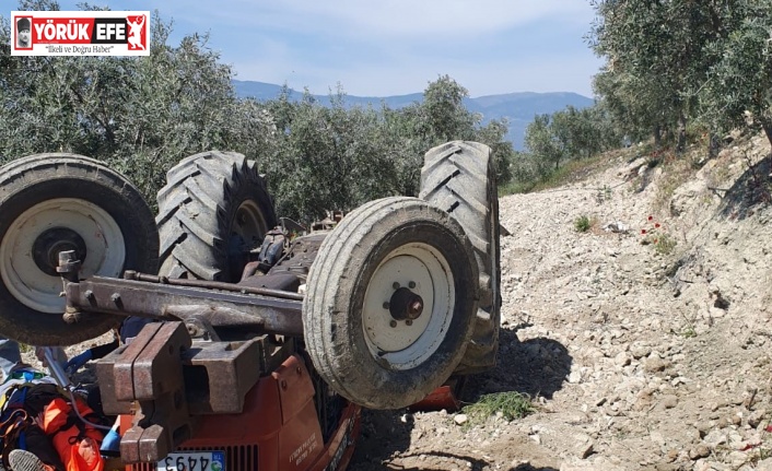 Devrilen traktörün altından yardım istedi