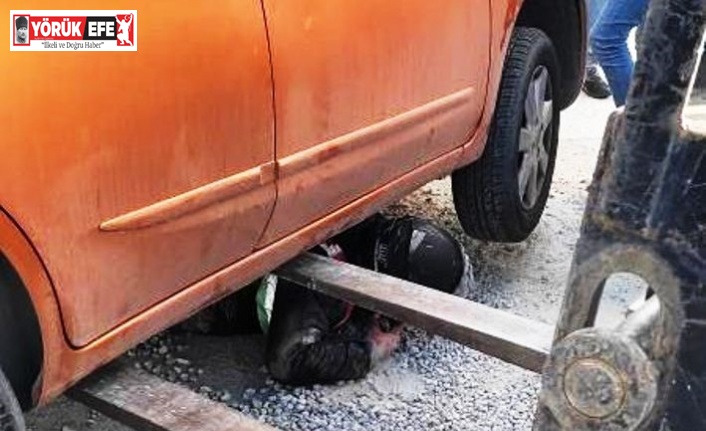 Mıcırda kayan motosiklet otomobilin altına girdi